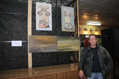 Валерій Юхимов біля своїх картин на виставці "Мистецтво без обмежень"